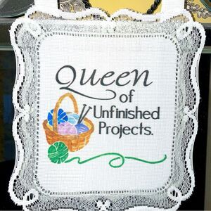 Queen of Unfinished Projects hanging cloth sign with lace border & white hanger